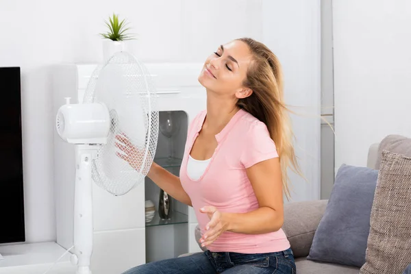 Жінка сидить перед вентилятором — стокове фото
