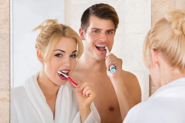 Jong paar poetsen tanden in badkamer — Stockfoto