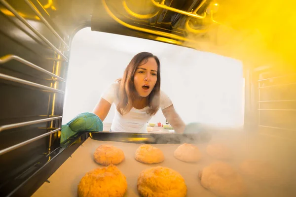 Mulher olhando para biscoitos queimados — Fotografia de Stock