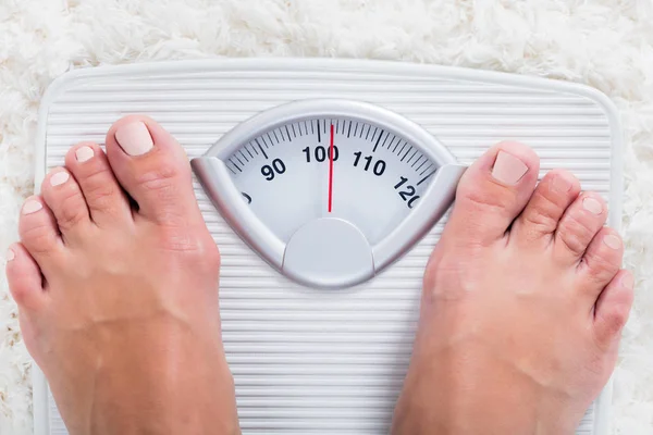 Pessoa em pé na balança de pesagem — Fotografia de Stock