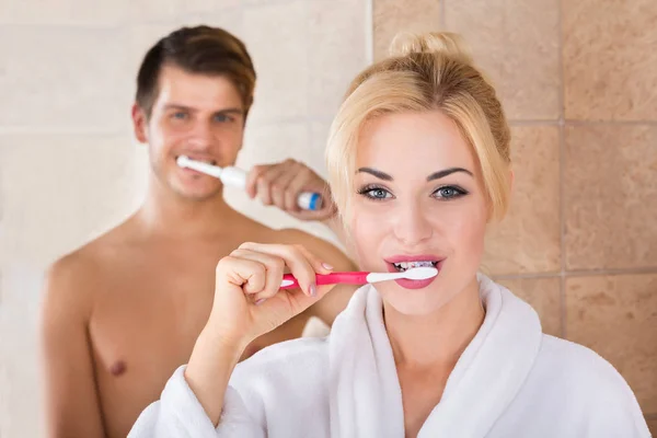 Jovem casal escovar os dentes no banheiro — Fotografia de Stock