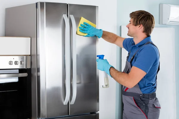 Férfi takarítás rozsdamentes hűtőszekrény — Stock Fotó