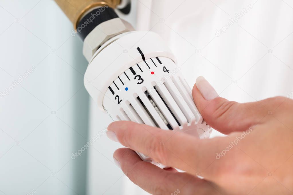 Person Adjusting Thermostat