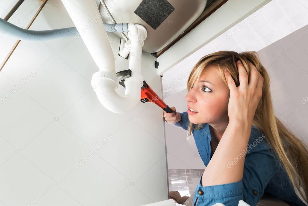 Woman Fixing Sink Pipe 
