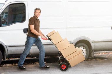 Delivery Man Pushing Parcels clipart
