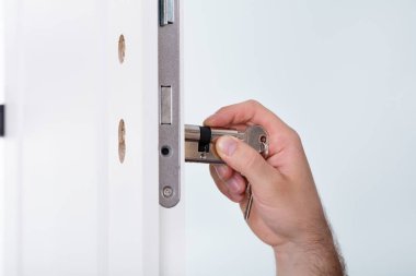 Man Installing Door Lock  clipart