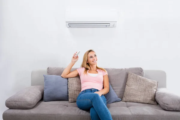 Woman Operating Air Conditioner — Stock Photo, Image