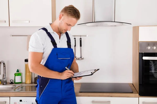 Reparador escribiendo en portapapeles — Foto de Stock