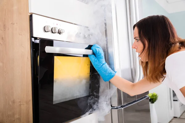 Donna guardando fumo forno — Foto Stock