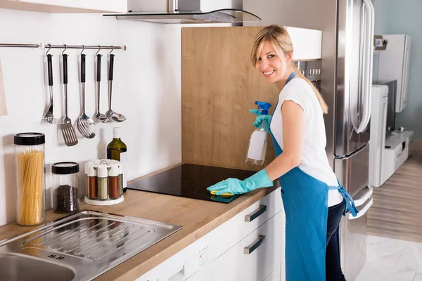 Γυναίκα καθαρισμός κουζίνα επαγωγής — Φωτογραφία Αρχείου