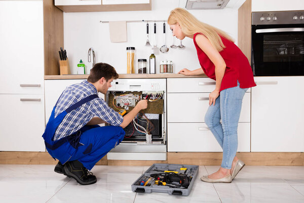 Техник проверяет посудомоечную машину
