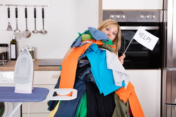 Vrouw met stapel kleren — Stockfoto