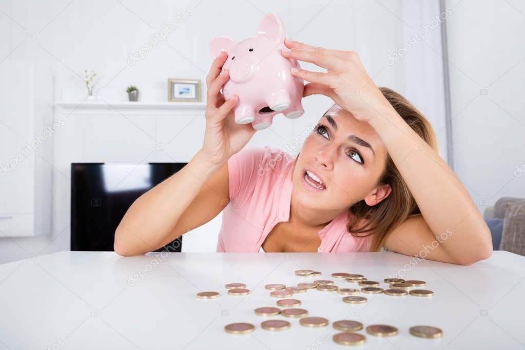 Woman Emptying Piggybank 