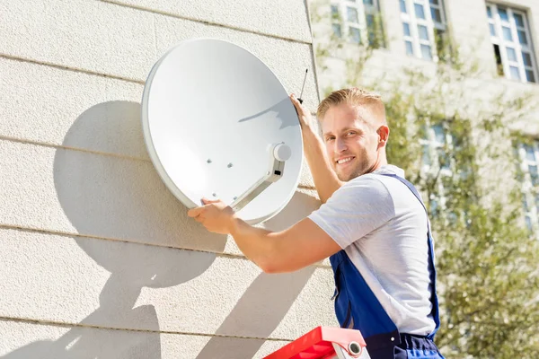 Mann passt Fernsehschüssel an — Stockfoto