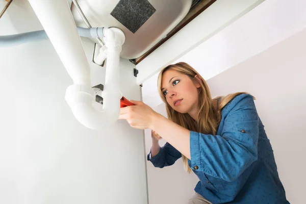 Mulher que fixa o tubo do dissipador — Fotografia de Stock