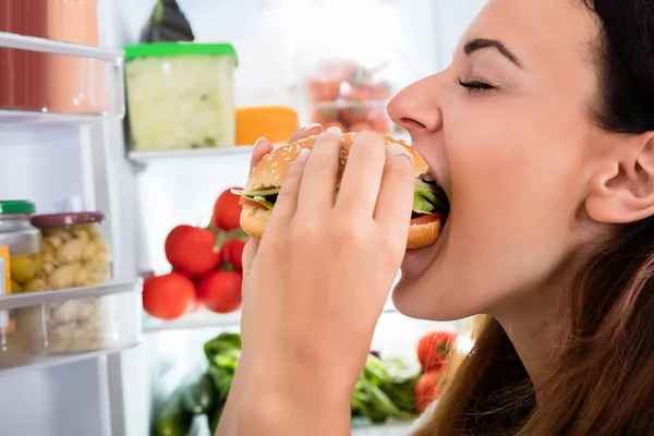 Kobieta jedzenie hamburgerów — Zdjęcie stockowe
