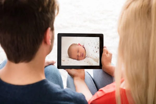 Coppia guardando foto del bambino — Foto Stock