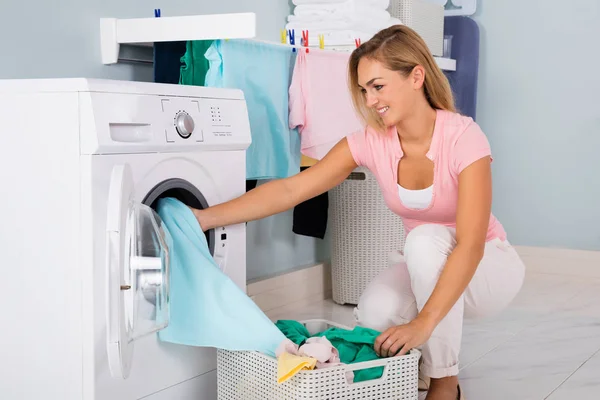 Mujer sonriente poniendo ropa — Foto de Stock