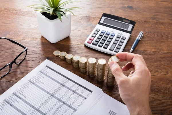 Persona apilando monedas en el escritorio —  Fotos de Stock