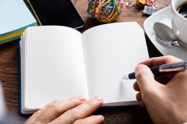 Üstünde defter kalem tutan kişi