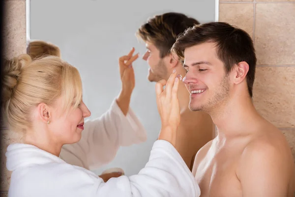 Woman Putting Cream On Man — Stock Photo, Image