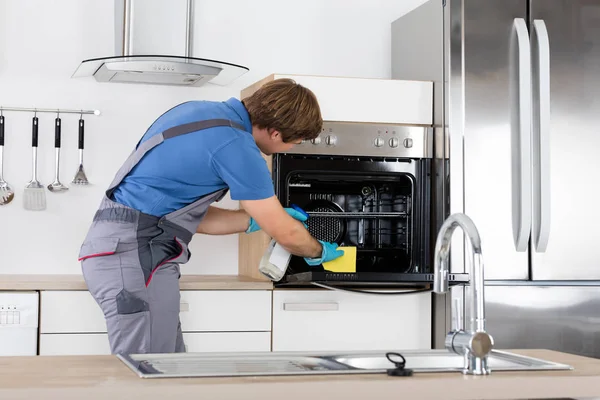 Man In Overall Cleaning Oven — Stock Photo, Image