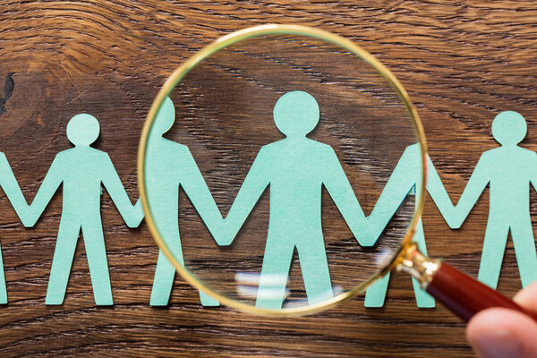 Человек, использующий увеличительное стекло
