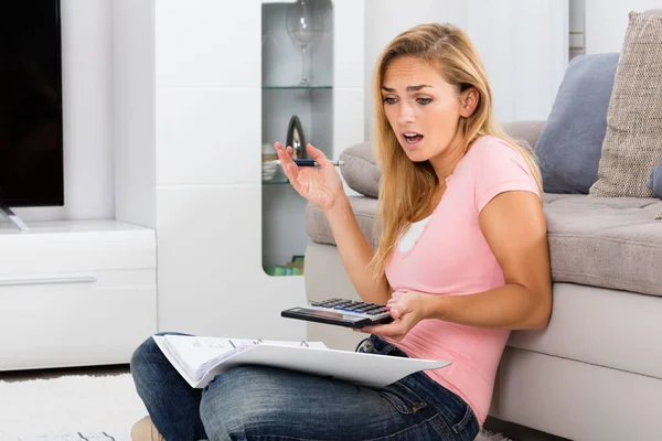 Mujer mirando calculadora — Foto de Stock