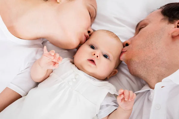 Father And Mother Kissing Child — Stock Photo, Image