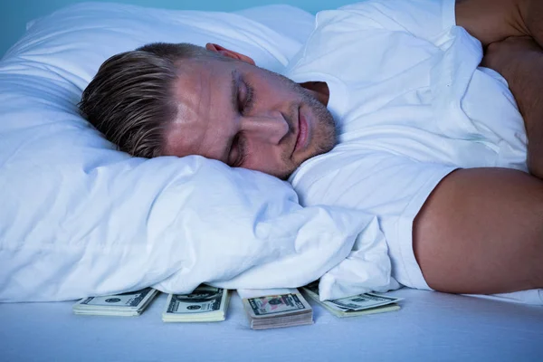 Hombre durmiendo con billetes de moneda — Foto de Stock