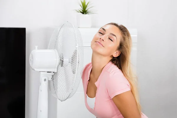 Mulher sentada na frente do ventilador — Fotografia de Stock