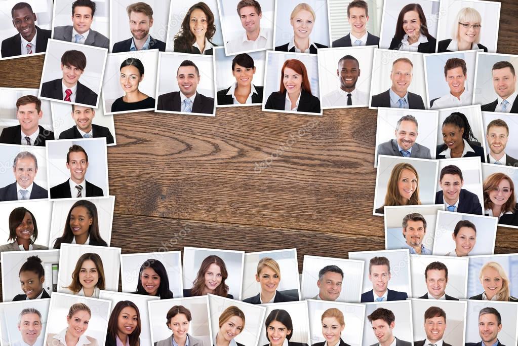 High Angle View Of Photos Of Smiling Multiethnic Business People Portraits Collage On Wooden Table. 