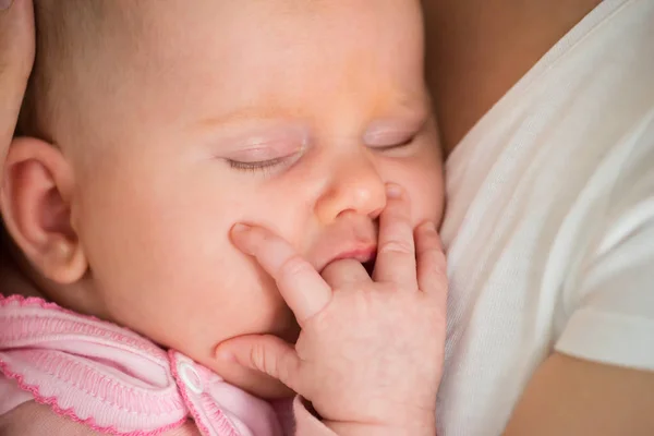 Bebé durmiendo en mamá brazos — Foto de Stock