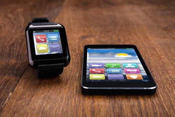 Mobiltelefon med Smart Watch-klocka på trägolv — Stockfoto