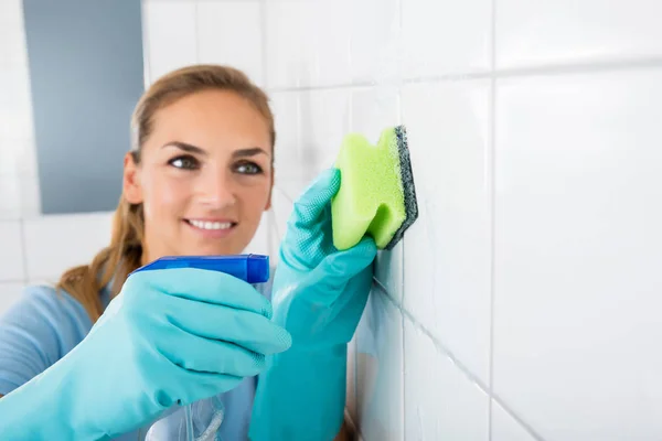 Sonriente mujer limpieza pared — Foto de Stock