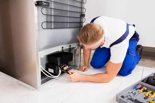 Técnico masculino que comprueba el refrigerador — Foto de Stock