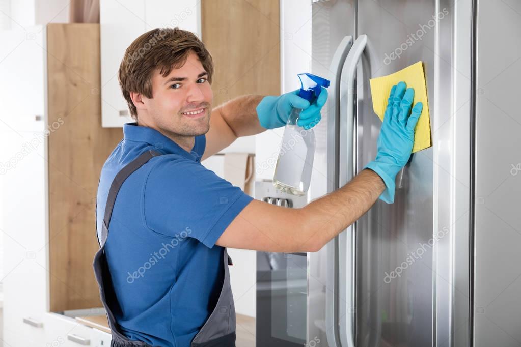 Man Cleaning Stainless Refrigerator