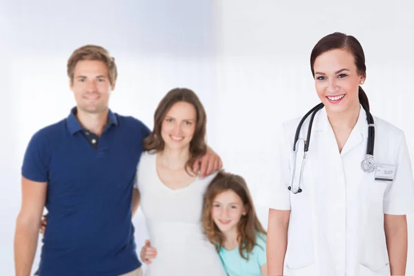 Médico de pie frente a la familia — Foto de Stock