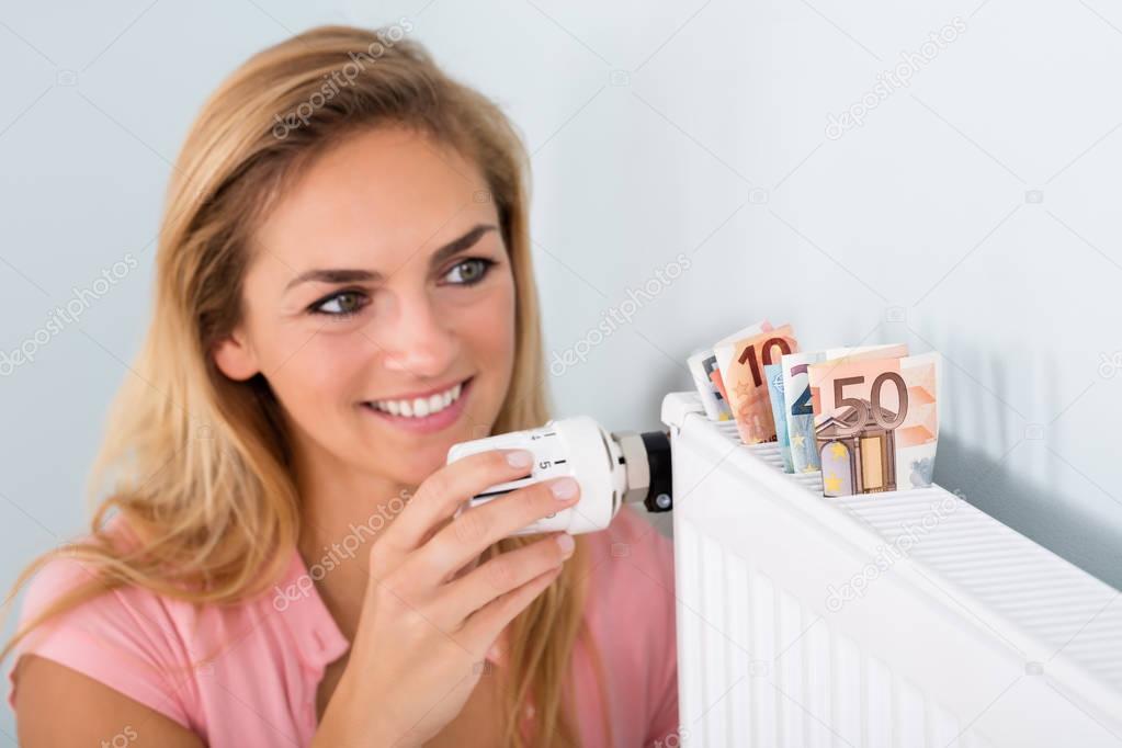 Woman Adjusting Thermostat 