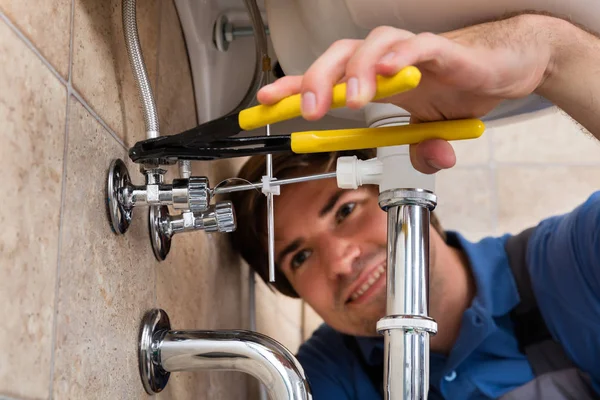 Klempner repariert Waschbecken im Badezimmer — Stockfoto