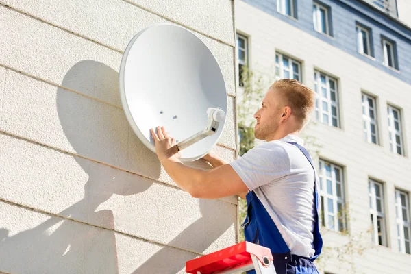 Hombre montaje TV satélite plato —  Fotos de Stock