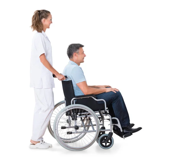 Dozorca pchanie niepełnosprawnych pacjenta — Zdjęcie stockowe