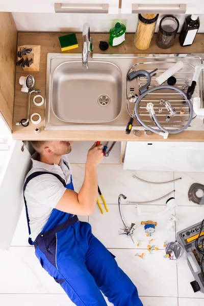 Manliga rörmokare reparera diskbänk — Stockfoto