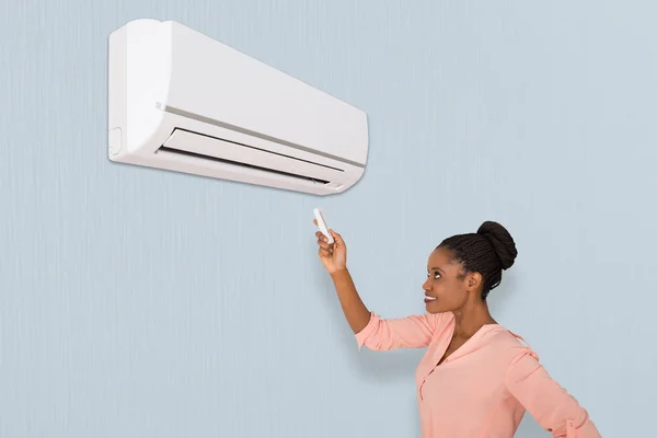 Vrouw die airconditioner — Stockfoto