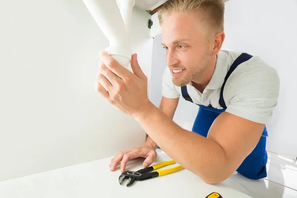 Mannelijke loodgieter repareren wastafel — Stockfoto