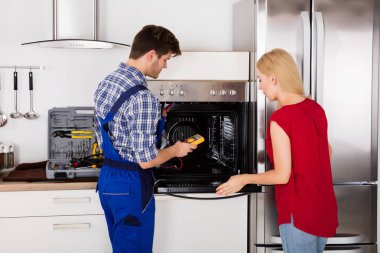 Male Worker Repairing Oven  clipart
