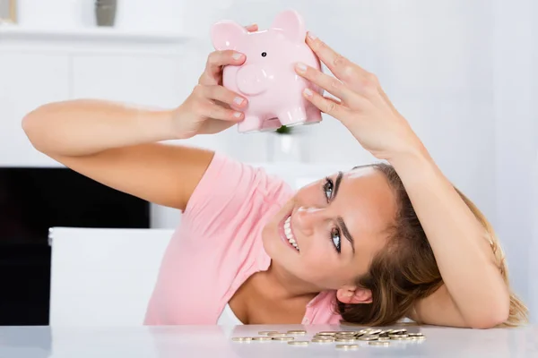 Mujer vaciando Piggybank — Foto de Stock