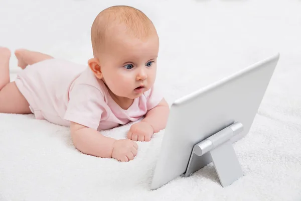 Baby schaut auf digitales Tablet — Stockfoto