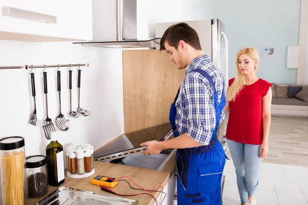 Reparateur onderzocht houtkachel — Stockfoto