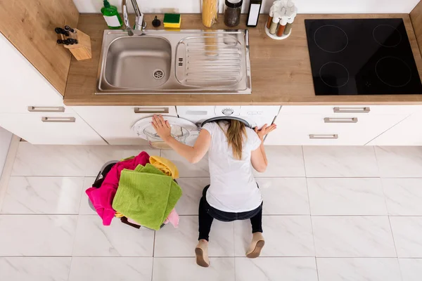 Mujer que comprueba la lavadora — Foto de Stock